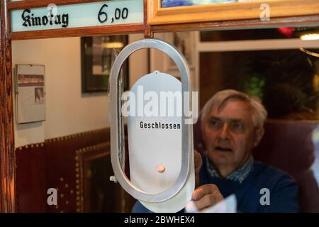 Quernheim, Germania. 27 maggio 2020. L'operatore cinematografico Karl-Heinz Meier si trova dietro la biglietteria chiusa del cinema Lichtburg, nell'idilliaco villaggio di Quernheim, probabilmente la più piccola città cinematografica della Germania. I cinema sono chiusi da marzo - molti sono ora minacciati di fallimento. La crisi di Corona colpisce tutti, dai piccoli cinema in campagna ai multiplex della città. Credit: Friso Gentsch/dpa/Alamy Live News Foto Stock