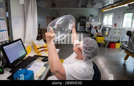 Sarstedt, Germania. 20 Maggio 2020. Un dipendente sottopone un preservativo prodotto di recente a un controllo di qualità nello stabilimento CPR GmbH. Ogni singolo preservativo viene controllato elettronicamente man mano che la produzione procede. Secondo il boss dell'azienda Kesselring, CPR è uno dei maggiori produttori di preservativi in Europa. Credit: Julian Stratenschulte/dpa/Alamy Live News Foto Stock