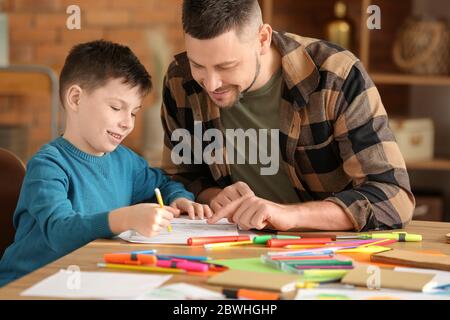 Insegnante di disegno che dà lezioni facoltative a scuola Foto Stock