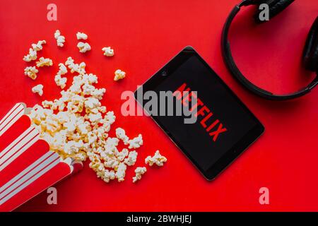 Calgary, Alberta. Canada. 1 giugno 2020. Un iPad con il logo Netflix sullo schermo su sfondo rosso con popcorn e cuffie Foto Stock