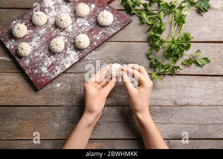 Donna che prepara gustosi gnocchi sul tavolo Foto Stock