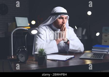 Uomo d'affari arabo che lavora in ufficio a tarda notte Foto Stock