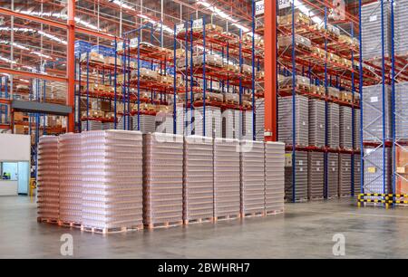 Pallet di pila di vetro vuota in area di corto circuito all'interno del magazzino di distribuzione. Foto Stock