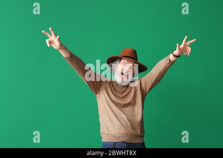 Un uomo anziano cool che balla su sfondo colorato Foto Stock
