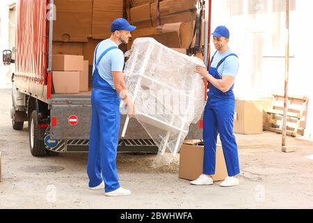 Caricatori che prelevano mobili dal camion all'aperto Foto Stock