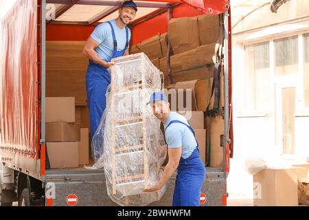 Caricatori che prelevano mobili dal camion all'aperto Foto Stock