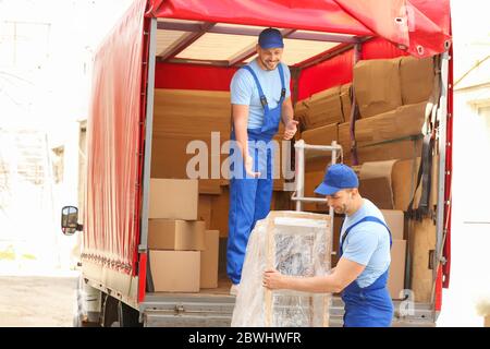 Caricatori che prelevano mobili dal camion all'aperto Foto Stock