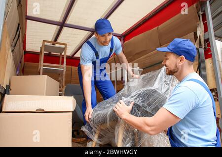 Caricatori che prelevano mobili dal camion Foto Stock