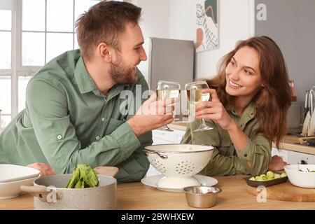 Felice coppia giovane di bere vino in cucina Foto Stock