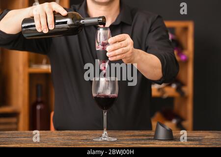 Aeratore con bicchiere, bottiglia di vino e formaggio su fondo scuro Foto  stock - Alamy