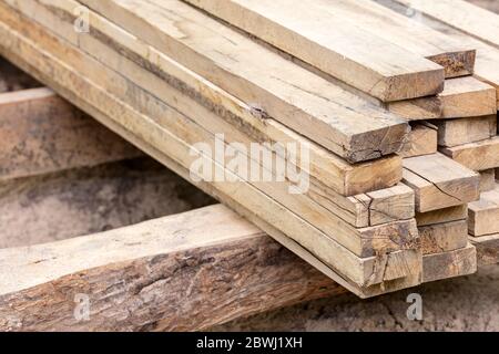 pila di tavole di legno grezzo marrone naturale in cantiere. tavole di legno impilate. Foto Stock