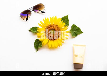 crema solare spf50 cosmetici cura della salute per la pelle viso con occhiali da sole di stile di vita donna e girasole fiore giallo di stile di vita donna relax estate Foto Stock