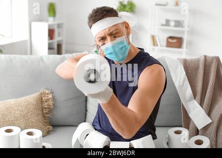 Uomo divertente con pistola giocattolo e carta igienica che gioca a casa.  Concetto di epidemia di coronavirus Foto stock - Alamy