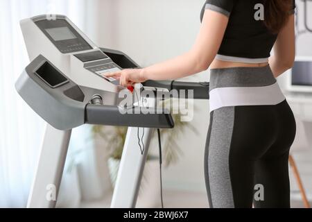 Allenamento sportivo per giovani donne sul tapis roulant a casa Foto Stock