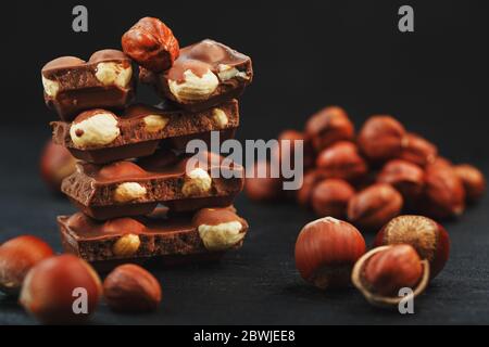 Cioccolato con nocciola su sfondo nero da vicino. Foto Stock