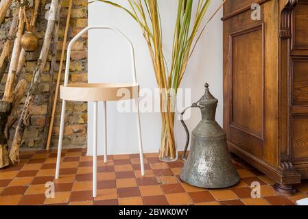 tavolo e vaso moderni vicino ad una vecchia cassettiera Foto Stock