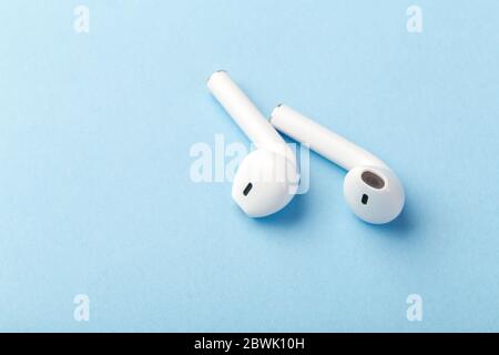 le moderne cuffie wireless bluetooth si trovano su uno sfondo blu Foto Stock