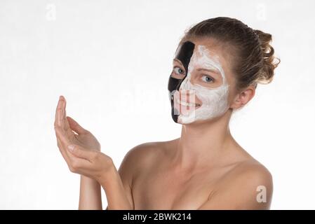 Felice bellissima ragazza con acne sorridente su sfondo bianco in una maschera di personalizzazione dei colori bianco e nero Foto Stock