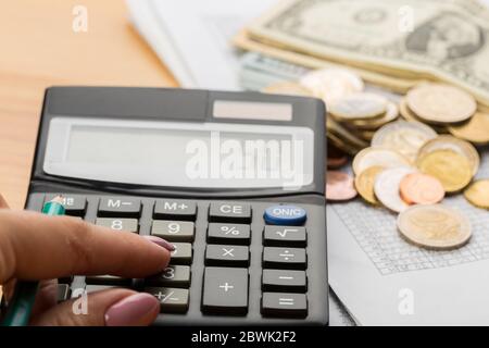 Monete e banconote con un calcolatore: Risparmio, finanza, economia