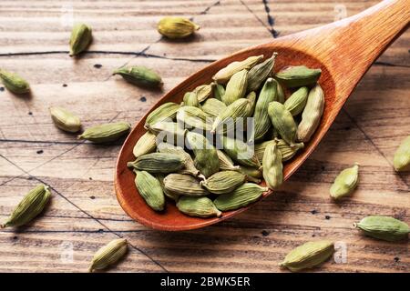 Grani interi di cardamomo, un bastone di anice stellato di cannella e zucchero di canna. Spazio di copia. Ingredienti per la preparazione del tè indiano masala bevanda. Legno backgr Foto Stock