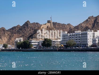 Vista sulla baia dalla Corniche di Mutrah verso il Forte di Mutrah, Muscat, Sultanato di Oman. Foto Stock
