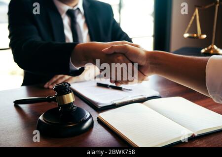 L'avvocato sta attualmente scuotendo le mani con il cliente circa il successo nella risoluzione del caso. Foto Stock