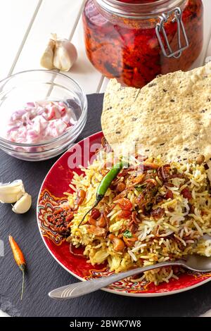 Pollo indiano Halal o Biryani di montone servito con yogurt pomodoro raita e achar. Sfondo bianco. Messa a fuoco selettiva. Foto Stock