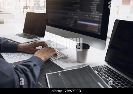 Asian uomo Working code sviluppatore di programmi computer web sviluppo lavorare software di progettazione su scrivania in ufficio. Foto Stock