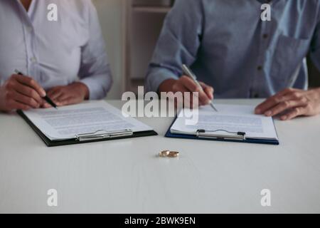 Moglie e marito firmano i documenti di divorzio presso l'ufficio legale. Foto Stock