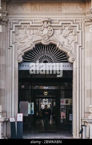 Siviglia, Spagna - 17 gennaio 2020: Ingresso dell'Università di Siviglia, una delle università più classificate della Spagna, uomo che cammina fuori, movimento sfocato. Foto Stock