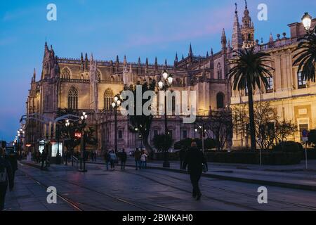 Siviglia, Spagna - 17 gennaio 2020: Vista sulla cattedrale illuminata di Siviglia, la capitale della regione dell'Andalusia nel sud della Spagna e un popolare a. Foto Stock