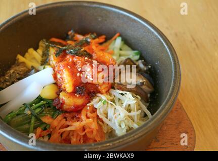 Primo piano Bibimbap o riso misto coreano tradizionale con carne e verdure assortite in Hot Stone Bowl Foto Stock