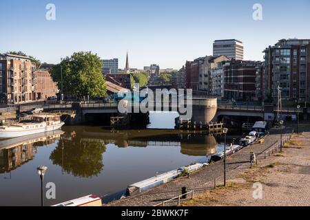 Bristol, Inghilterra, Regno Unito - 25 maggio 2020: Un autobus a due piani attraversa il ponte Redcliffe, mentre la luce del mattino splende sulle banchine e sugli edifici di Bristol Foto Stock