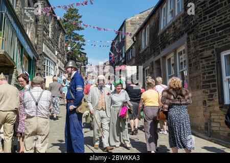 Visitatori e riattori in costumi e uniformi durante il fine settimana degli anni '40 a Haworth, West Yorkshire Foto Stock