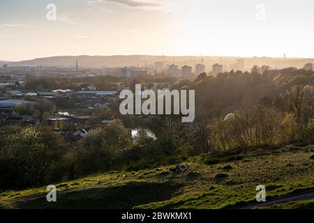 Bristol, Inghilterra, Regno Unito - 3 aprile 2020: Il sole tramonta dietro lo skyline di Bristol visto dal parco di Trooper's Hill. Foto Stock