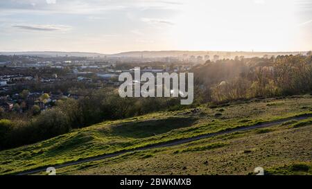 Bristol, Inghilterra, Regno Unito - 3 aprile 2020: Il sole tramonta dietro lo skyline di Bristol visto dal parco di Trooper's Hill. Foto Stock