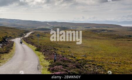 Applecross, Scozia, Regno Unito - 24 settembre 2013: Un giro in motociclista e passeggero attraverso la brughiera a Cuaig vicino Applecross sulla rotta North Coast 500 Foto Stock