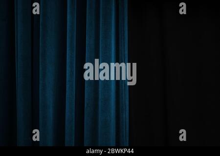 Tenda di velluto blu scuro su un lato di un palco nero, concetto di sfondo dell'evento con ampio spazio per la copia Foto Stock