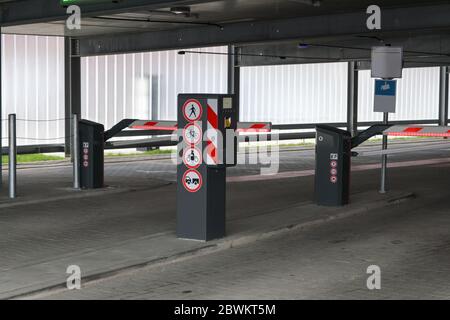 Ingresso a un parcheggio a più piani o garage con barriere e colonne per il parcheggio, concetto di traffico per molti veicoli nel centro della città, Foto Stock