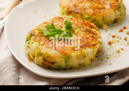 Cutlet vegetariane vegetali sane di carote, broccoli, patate con erbe su un piatto bianco Foto Stock