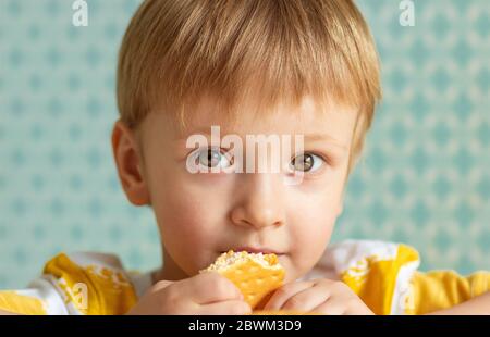 concetto - cura dentale, odontoiatria pediatrica. bambino con biscotti guarda nel telaio. primo piano Foto Stock