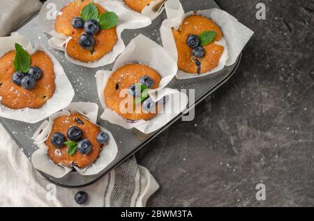 Muffin fatti in casa ai mirtilli con frutti di bosco su un tavolo Foto Stock