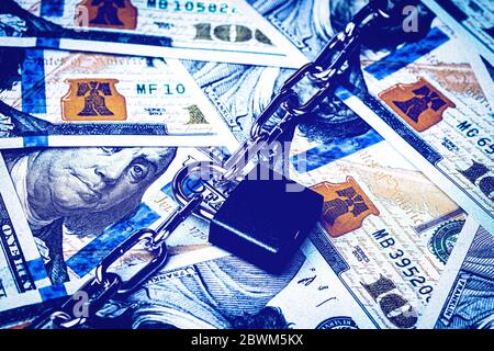 Banconote in dollari, lucchetto nero e catena metallica. Blocco di denaro o concetto di sicurezza. Blocco account. Foto Stock