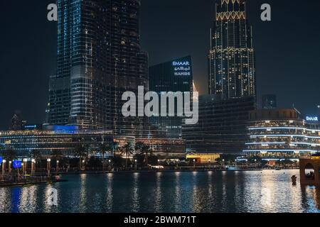 Dubai, Emirati Arabi Uniti - Febbraio 2020 : piscina con riflesso e illuminato alto Burj-Khalifa e Dubai Mall edifici di notte, Emirati Arabi Uniti. Foto Stock