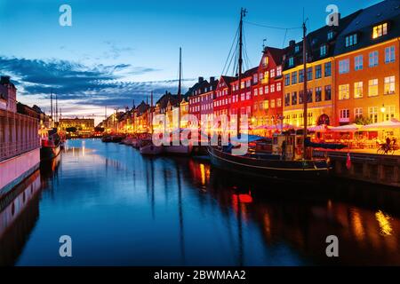 Copenaghen, Danimarca. Vista della famosa area di Nyhavn nel centro di Copenhagen, Danimarca di notte. Varie barche ormeggiate con edifici storici e clou Foto Stock