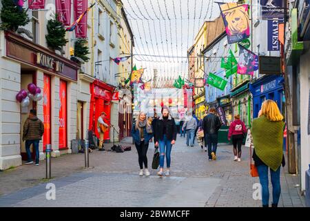 GALWAY, IRLANDA - 6 NOVEMBRE 2019: Il centro di Galway, Irlanda, in una serata d'autunno nuvolosa, con edifici colorati e gente che passa. V Foto Stock