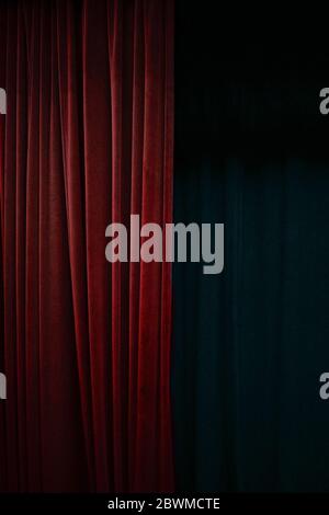 Tenda di velluto rosso scuro su un lato di un palco nero, sfondo verticale per eventi con ampio spazio per la copia Foto Stock