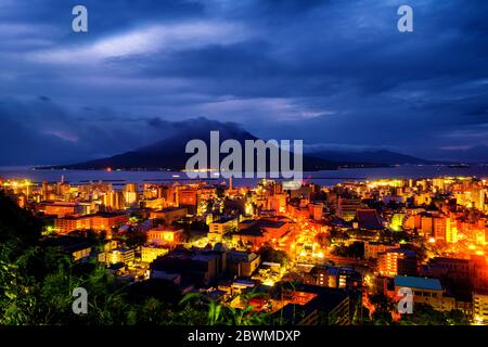 Kagoshima, Giappone. Vista sulla montagna Sakurajima un vulcano attivo. Vista aerea della città di Kagoshima in Giappone di notte Foto Stock