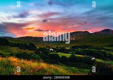 Donegal, Irlanda. Paesaggio in Dunlewey con chiesa abbandonata in Donegal, Irlanda. Colorato tramonto Cielo. Verde paesaggio di sera Foto Stock