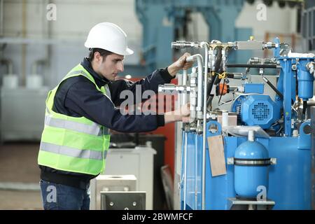 Ritratto di un uomo , ingegnere di fabbrica in abiti da lavoro che controlla il processo di lavoro presso il produttore dell'aeroplano. Foto Stock